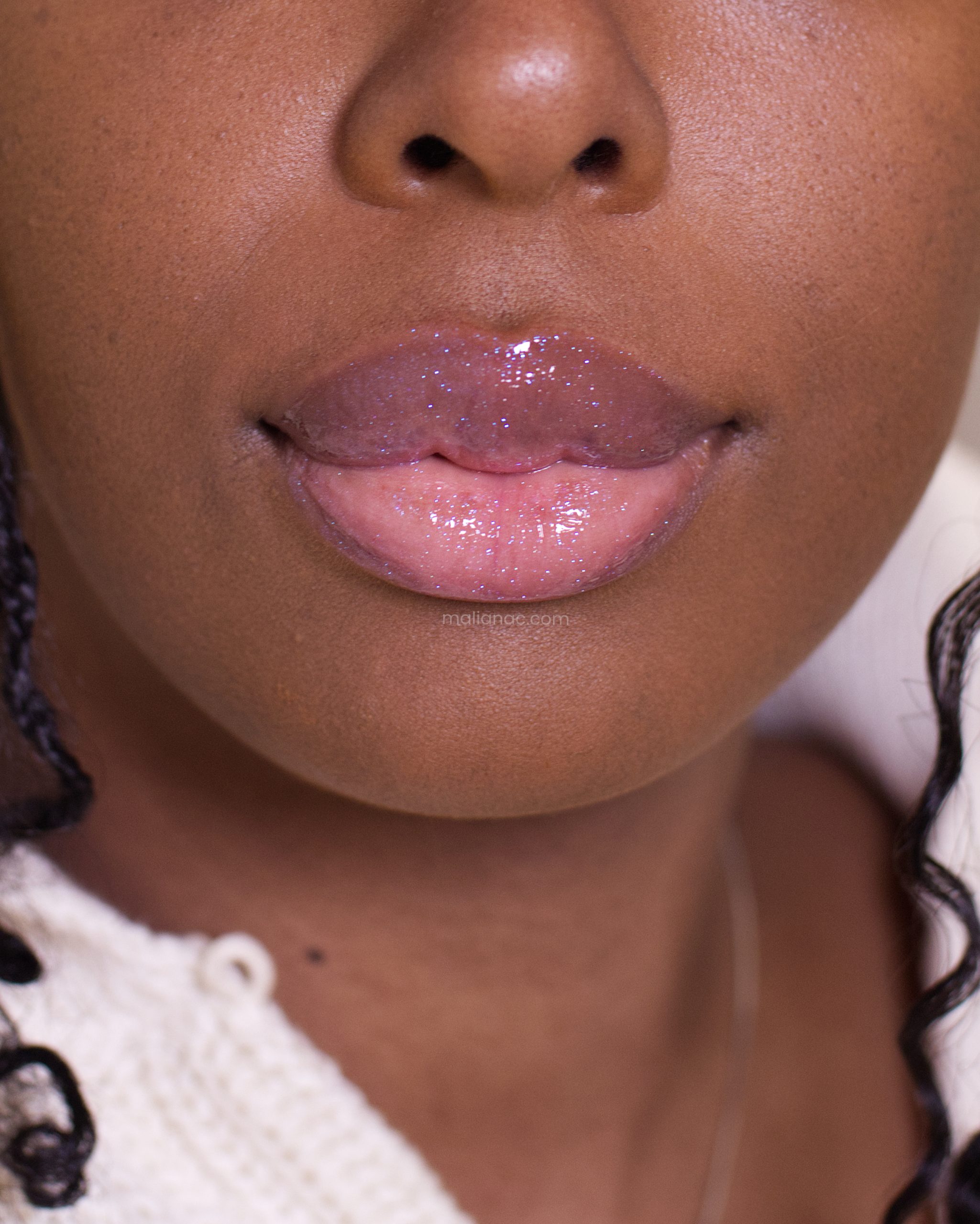 Fenty Beauty lip oil in shade Miss Jellyfish swatched on dark skin